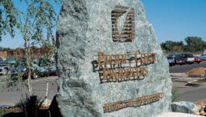 A prominent rock situated in a parking lot near the Pacific Coast.